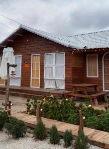 eine Blockhütte mit einer Holzterrasse und einem Picknicktisch in der Unterkunft Retro House Mộc Châu in Mộc Châu