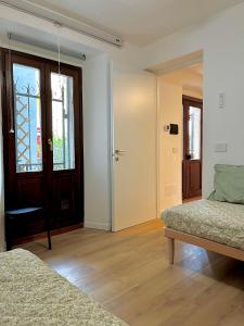 ein weißes Zimmer mit 2 Betten und einer Tür in der Unterkunft Ca’ 2810 Vacation Rental Baveno in Baveno