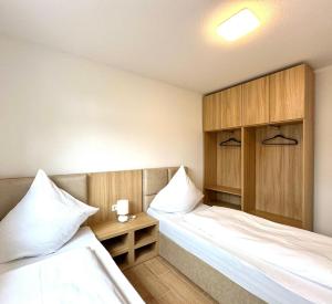 a room with two beds and a nightstand between them at Tiny House Village Löffingen in Löffingen