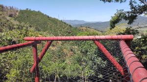 a red fence with a mountain in the background at La tina in Yolombó