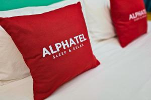 ein Bett mit zwei roten Kissen darauf in der Unterkunft Phu Jaya Floresta Resort by ALPHATEL in Chiang Mai
