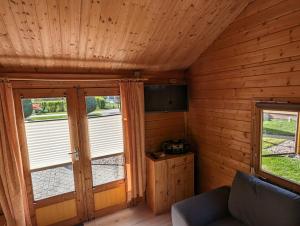 una sala de estar con 2 ventanas en una cabaña de madera en Ferienhaus 2, en Ludorf