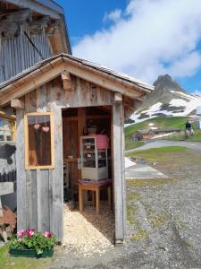 a small building with a refrigerator and a mountain at Faschina Apartment - Top 1 in Fontanella