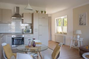 eine Küche und ein Wohnzimmer mit einem Tisch und Stühlen in der Unterkunft Gästehaus Lehmann in Schönfeld