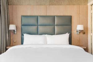 1 dormitorio con 1 cama grande con almohadas blancas en Sonder L'Edmond Parc Monceau en París