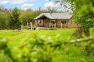 a small house with a porch in a field at Kestrel - Sweffling Hall in Rendham