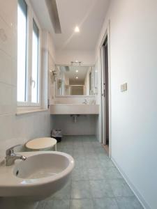 a white bathroom with a sink and a mirror at Hotel Tirreno in Alassio