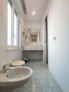 a white bathroom with a sink and a mirror at Hotel Tirreno in Alassio +105 photos