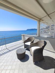 two chairs and a table on a balcony with the ocean at Hotel Tirreno in Alassio