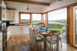 een keuken met een tafel en stoelen en uitzicht bij Finest Retreats - Bryn Du in Aberdaron