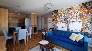 ソポトにあるKomfortowy apartament Santiagoのリビングルーム(青いソファ付)、キッチン