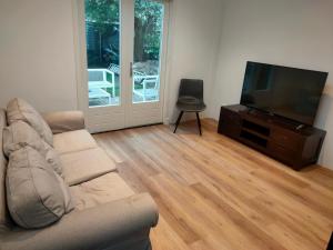 a living room with a couch and a flat screen tv at House with garden in the center close to the sea and Amsterdam in Beverwijk