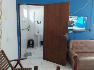 Una puerta a un baño con TV en una habitación en POUSADA PERLLA's Pindamonhangaba en Pindamonhangaba