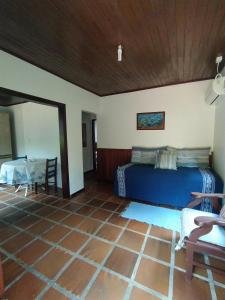 a bedroom with a blue bed and a table at Pousada do Pescador in Florianópolis