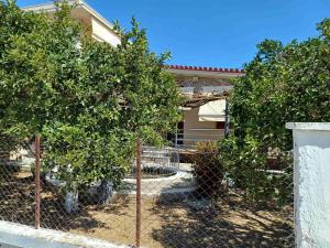 a fence in front of a house with two trees at Villa Chrisalena in Nafplio
