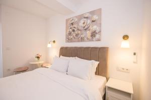 波雷奇Mind apartment and rooms的卧室里有一张白色的床,墙上挂着一幅画