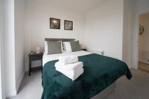 a bedroom with a bed with white towels on it at Canary Haven- Luxury 2 bedroom 2 bathroom Apartment in London