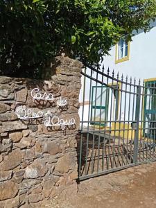 a stone wall with a gate and a fence at Casa do Olho d'Água in Portalegre