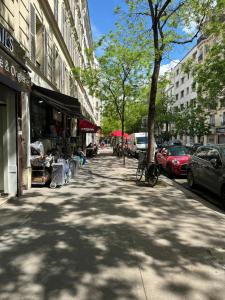 a city street with cars parked on the sidewalk at Appartement parisien (12ème) in Paris