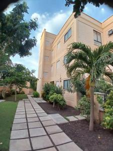 a building with a palm tree in front of it at Sandbox Apartment 4 Diani Beach Kenya in Ukunda