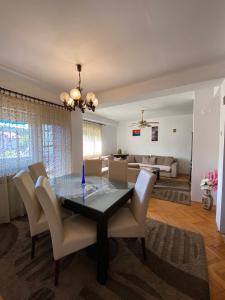 a dining room and living room with a table and chairs at Dena Apartment in Kumanovo