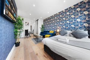 Modern 1 Bed Flat - Near Heathrow - UB3 London في لندن: غرفة نوم بسرير كبير وجدار ازرق