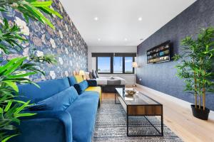 Modern 1 Bed Flat - Near Heathrow - UB3 London في لندن: غرفة معيشة مع أريكة زرقاء والنباتات