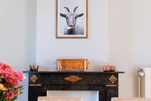 a picture of a goat on top of a fireplace at De Koperen Geit in Kanne