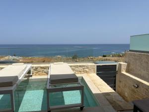uma varanda com uma mesa e vista para o oceano em Sofia Suite, a seafront hideaway ! em Panormos Rethymno