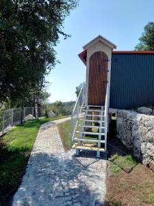 eine Treppe, die zu einem Gebäude mit einer Holztür führt in der Unterkunft Canastro do Vidoeiro in Vieira do Minho
