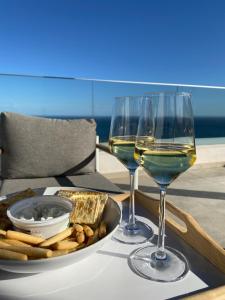 - une table avec deux verres de vin et un plateau de fromage dans l'établissement Heerlijk penthouse, dakterras met prachtig zeezicht, kingsize bed, zwembad, 700m van strand, à Torre de Benagalbón