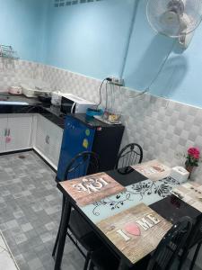 - une cuisine avec deux tables, une table et des chaises dans l'établissement Blue House Hat Yai, à Hat Yai