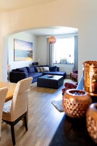 - un salon avec un canapé bleu et une table dans l'établissement De Koperen Geit, à Kanne