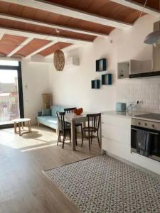 a kitchen and living room with a table and chairs at Can Llavi in Canet de Mar