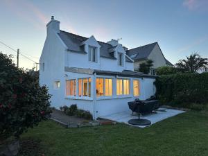 a white house with a tv in the yard at Pied à terre Portsallais in Ploudalmézeau