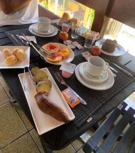 een tafel met borden en kopjes koffie bij Pousada Du’Forte in Praia do Forte