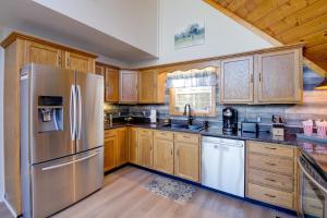 uma cozinha com armários de madeira e um frigorífico de aço inoxidável em Stylish Smoky Mountains Cabin with Views and Game Room em Sevierville