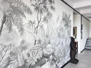 een persoon die voor een muurschildering van planten staat bij 87029house in Scalea