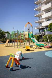 a playground with slides and play equipment in front of a building at Seaside Apartment in Gdańsk