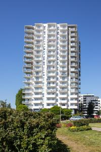 a tall white apartment building in a city at Seaside Apartment in Gdańsk