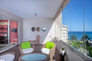 een balkon met stoelen en tafels en uitzicht op de oceaan bij Hallmark Beach by TrulyCyprus in Limassol