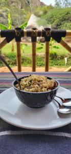 a bowl of food on a plate on a table at Hill Stone View Hampi in Hampi