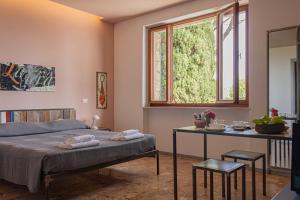 a bedroom with a bed and a table and a window at La Bruna in Porto Santo Stefano