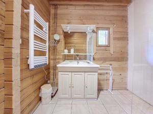 La salle de bains est pourvue d'un lavabo blanc et de murs en bois. dans l'établissement Chalet chaleureux - 9 personnes - 3km des pistes - proche Morzine - Iaorana, à Saint-Jean-dʼAulps 14 autres photos