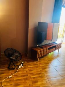 a living room with a flat screen tv on a table at The Urban Edge in Makerere