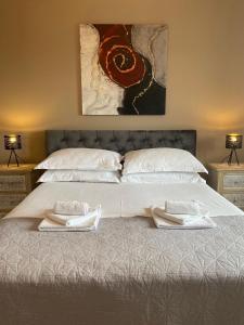 a bed with two pillows and a painting on the wall at Villa MirIva in Katuni