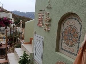 a building with a door and a mosaic on the side at Seaside Apartment 2 in Emborios
