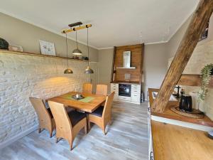 a kitchen and dining room with a wooden table and chairs at Ferienhaus Fehntraum - Entdecke Ostfriesland in Großefehn 