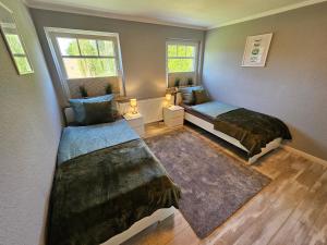 a small bedroom with two beds and a window at Ferienhaus Fehntraum - Entdecke Ostfriesland in Großefehn 