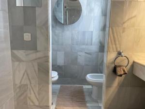 een badkamer met een douche, een toilet en een spiegel bij Beautiful 2 bedroom Apartment in Puerto Banus ! in Marbella
